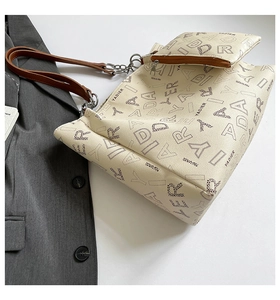 Close-up of vintage tote bag set with logo print and brown leather metal chain strap