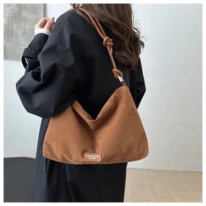 Brown suede hobo bag featuring knotted shoulder strap and silver adjustable buckle