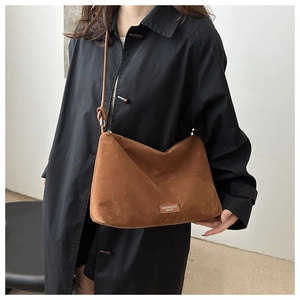 Brown suede shoulder bag with rectangular leather brand patch and stylish thin strap