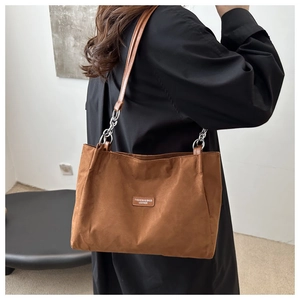Dettaglio borsa tote marrone vintage in pelle scamosciata con tracolla e catene in metallo