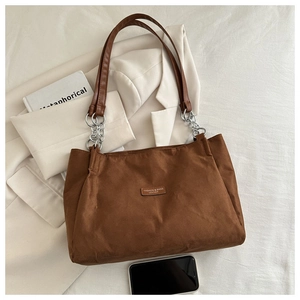 Dettaglio della borsa tote marrone scuro con texture opaca, catena d'argento e misure