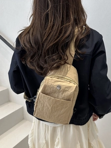 Fashionable khaki nylon crossbody bag with pleated texture shown on a model
