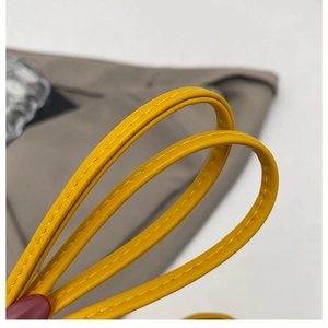 Macro del manico della borsa in pelle giallo brillante con dettagli di cuciture fini
