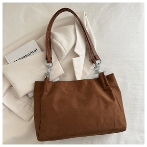 Dettaglio borsa tote in pelle scamosciata marrone con catena d'argento e manico