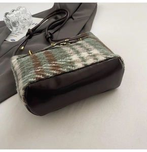 Détail du tweed vert et cuir brillant marron foncé sur ce sac seau rétro chic