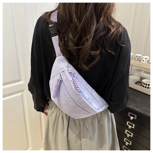 Detail of purple corduroy waist bag showing texture and woven zipper pull on back