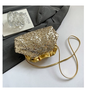 Dettaglio borsa da sera con paillettes dorate e finiture a pieghe con tracolla