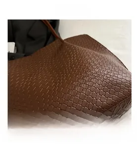 Close-up of brown woven leather texture on a large capacity tote shoulder bag