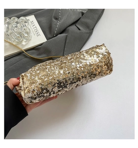 Dettaglio macro della borsa a mano con paillettes dorate con catena sottile in metallo