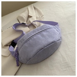 Detail view of light purple corduroy waist bag with adjustable strap in a lifestyle setting