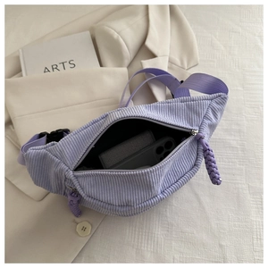 Close-up of light purple corduroy fanny pack showing internal storage and metal zipper