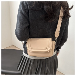 Detailed back view of apricot flap shoulder bag with textured lines and wide strap