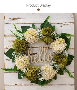 Close-up of artificial hydrangea wreath with green leaves and a wooden hello sign