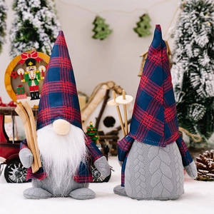 Detail view of two Christmas gnomes with plaid hats and wooden skis in a snowy scene