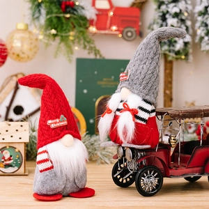 Detailed view of handmade Christmas gnomes with knitted hats and Merry Christmas tags