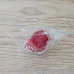 Close-up of a red knitted Christmas hat ornament with a Merry Christmas fabric tag