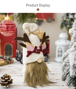 Detail of knitted Christmas gnome with reindeer antlers and festive bow tie on soft fur