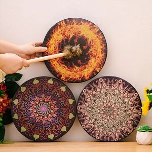Three Bohemian shaman drums with unique patterns and wooden mallets on a tabletop