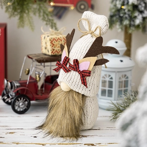 Detail of Christmas gnome with knitted shell hat, brown antlers and plaid bow decoration