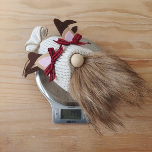 Weight measurement of a knitted reindeer gnome Christmas decoration at 149.6g on a scale