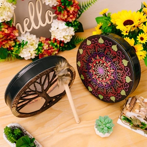 Detail of bohemian shaman drums featuring Tree of Life and Mandala patterns with drumstick