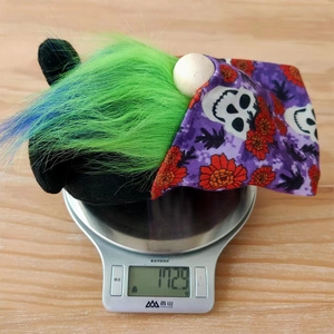 Detail shot showing a 172.9g weight measurement of a Halloween gnome with purple skull hat