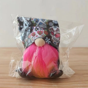 Detail of Day of the Dead gnome with skull print hat and pink beard in clear packaging