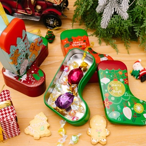 Close-up of Christmas stocking tin gift boxes filled with Godiva chocolates on a wooden table
