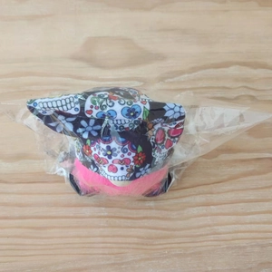 Detail of Halloween gnome doll with colorful sugar skull print in plastic packaging