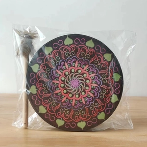 Detail of Bohemian hand drum featuring colorful mandala patterns with a plush drumstick