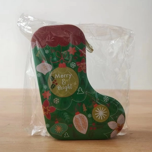 Detail of a Christmas stocking tin gift box featuring Merry & Bright festive patterns