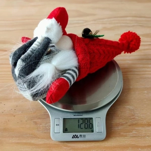 Detailed view of Nordic Christmas gnome plush weight measurement showing 128.6g on scale
