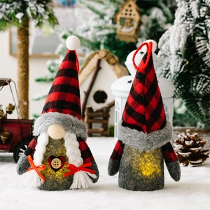 Close-up of lighted Christmas gnomes with red plaid hats on a snowy holiday display