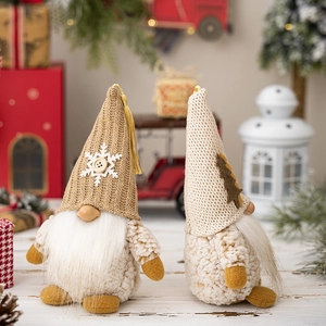 Set of 2 Christmas gnome plush decorations with knitted hats on warm festive background