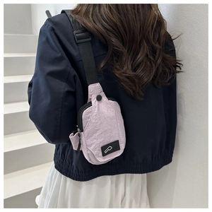 Detail view of light purple nylon crossbody waist bag showing texture and buckle detail