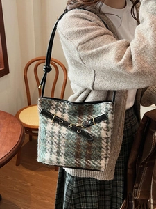 Sac seau rétro en tweed avec bandoulière en cuir et boucle dorée sur un mannequin