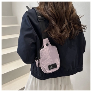 Detail view of the lavender nylon crossbody bag showing the adjustable black shoulder strap