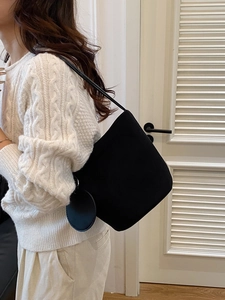 Borsa a secchiello nera minimalista con tracolla sottile e piccolo ciondolo portamonete