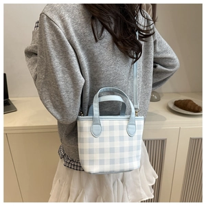 Detail of blue and white gingham canvas tote bag with adjustable strap and top handle