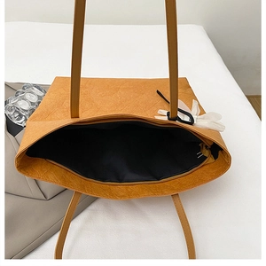 Top view of ginger yellow tote bag showing interior lining and flower charm detail