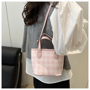 Pink and white checkered canvas tote bag with adjustable shoulder strap on female model