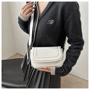Detailed side view of white faux suede crossbody bag with U-shaped stitching and wide strap