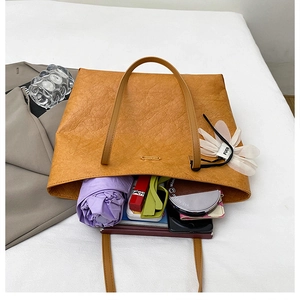 Top-down shot of a tan leather tote bag showing large interior space for daily items