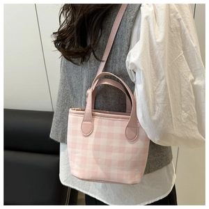 Close-up of pink gingham canvas mini tote bag worn with a casual vest and shirt