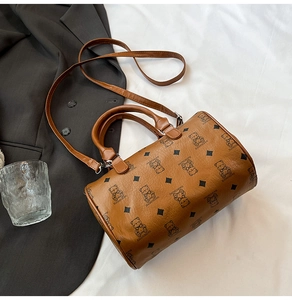 Détail d'un sac Boston marron avec imprimés ours, bandoulière et accessoires élégants