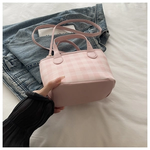 Detail of pink plaid handbag showing reinforced base and smooth synthetic leather texture