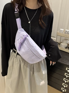 Riñonera de pana morada para mujer mostrada como bolso bandolera en una modelo
