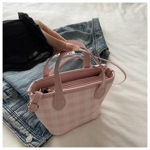 Top view of a pink checkered PU handbag with golden metal hardware and a detachable strap