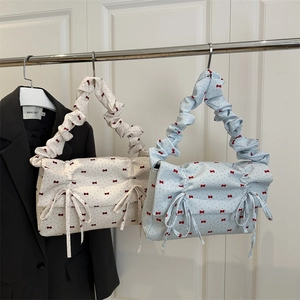 Pleated shoulder bags with red bows and polka dots in cream and light blue colors