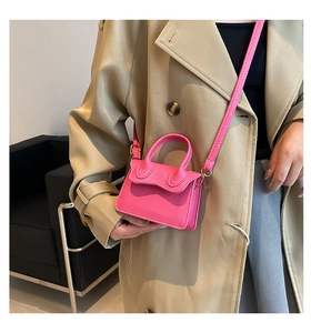 Détail du mini sac bandoulière rose fuchsia avec texture litchi et boucles dorées